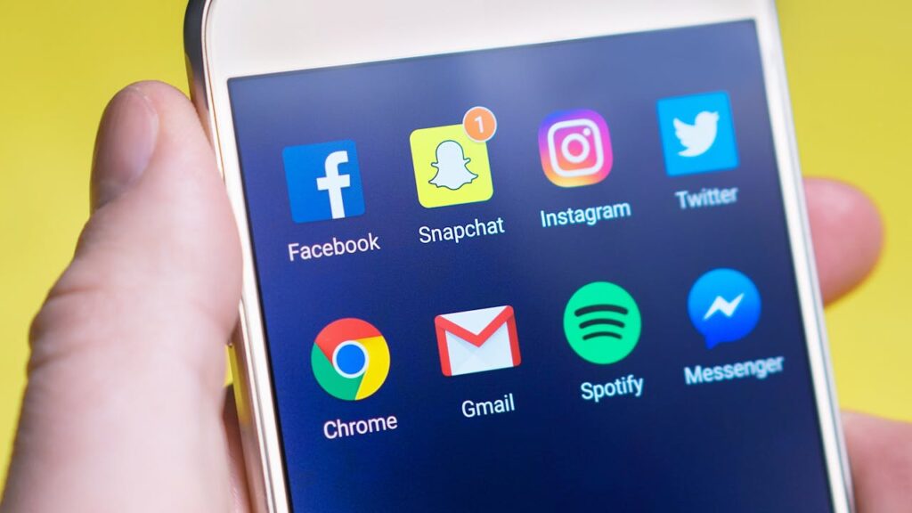 pexels-photo-533446 A person's hand holding a smartphone displaying social media and communication apps.