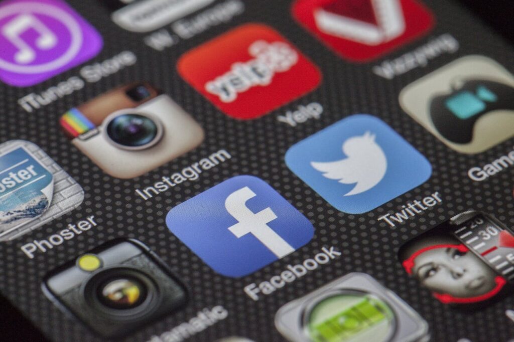 twitter-facebook-together-exchange-of-information-147413 Close-up image of various social media app icons on a smartphone screen.